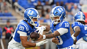 Nov 15, 2025; Durham, North Carolina, USA; Duke Blue Devils quarter back Darian Mensah (10) hands the ball to Duke Blue Devils running back Nate Sheppard (20) against the Virginia Cavaliers during the first quarter at Wallace Wade Stadium. 