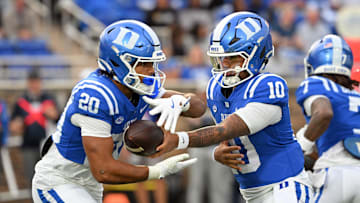 Nov 15, 2025; Durham, North Carolina, USA; Duke Blue Devils quarter back Darian Mensah (10) hands the ball to Duke Blue Devils running back Nate Sheppard (20) against the Virginia Cavaliers during the first quarter at Wallace Wade Stadium. Mandatory Credit: Zachary Taft-Imagn Images