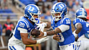 Nov 15, 2025; Durham, North Carolina, USA; Duke Blue Devils quarter back Darian Mensah (10) hands the ball to Duke Blue Devils running back Nate Sheppard (20) against the Virginia Cavaliers during the first quarter at Wallace Wade Stadium. Mandatory Credit: Zachary Taft-Imagn Images
