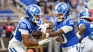 Nov 15, 2025; Durham, North Carolina, USA; Duke Blue Devils quarter back Darian Mensah (10) hands the ball to Duke Blue Devils running back Nate Sheppard (20) against the Virginia Cavaliers during the first quarter at Wallace Wade Stadium. Mandatory Credit: Zachary Taft-Imagn Images