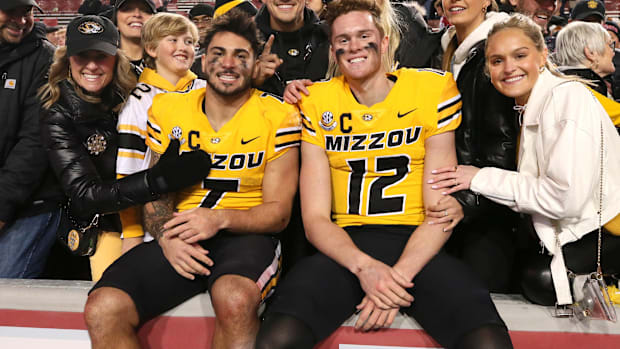 Missouri Tigers running back Cody Schrader (7) and quarterback Brady Cook (12) pose with fans