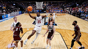Mar 20, 2025; Denver, CO, USA; Wisconsin Badgers guard John Blackwell (25) drives to the net as Montana Grizzlies guard Money Williams (0) defends against forward Steven Crowl (22) and guard Austin Patterson (20) and forward Te'Jon Sawyer (32) defend in the first half at Ball Arena.