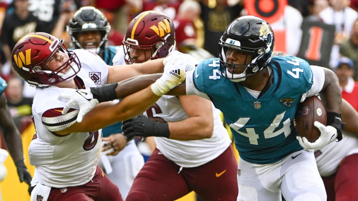 Sep 11, 2022; Landover, Maryland, USA; Jacksonville Jaguars linebacker Travon Walker (44) runs after an interception as Washington Commanders tight end John Bates (87) defends during the second half at FedExField. Mandatory Credit: Brad Mills-USA TODAY Sports