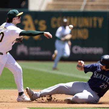 Oakland Athletics second baseman Zack Gelof (left) turns a double play during a game against the Seattle Mariners on June 6 at Oakland Coliseum.