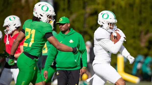 Oregon wide receiver Gary Bryant Jr. carries the ball as defensive back Aaron Flowers pursues during practice with the Oregon