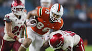 Sep 1, 2023; Miami Gardens, Florida, USA; Miami Hurricanes tight end Riley Williams (88) runs with the football as Miami Redhawks defensive back Eli Blakey (16) attempts a tackle during the fourth quarter at Hard Rock Stadium. Mandatory Credit: Sam Navarro-Imagn Images