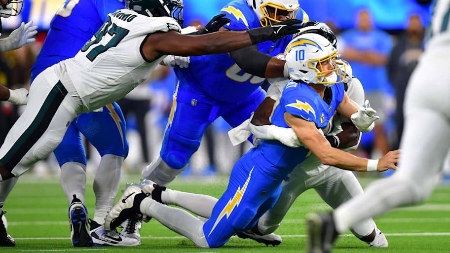 Philadelphia Eagles linebacker Jalyx Hunt tackles Los Angeles Chargers quarterback Justin Herbert.
