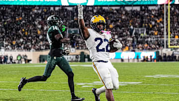 Michigan running back Justice Haynes (22) runs for a touchdown against Michigan State defensive back Malcolm Bell (14) during the second half at Spartan Stadium in East Lansing on Saturday, October 25, 2025.