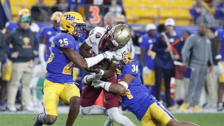 Nov 4, 2023; Pittsburgh, Pennsylvania, USA;  Pittsburgh Panthers defensive back Stephon Hall (25) commits a targeting penalty by hitting Florida State Seminoles wide receiver Vandrevius Jacobs (19) after a catch as Pitt defensive back Cruce Brookins (34) tackles during the fourth quarter against at Acrisure Stadium. The Seminoles won 24-7. Mandatory Credit: Charles LeClaire-USA TODAY Sports