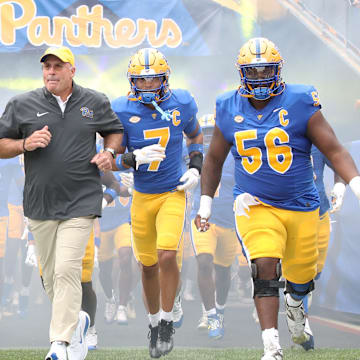 Sep 6, 2025; Pittsburgh, Pennsylvania, USA;  Pittsburgh Panthers running back Desmond Reid (0), head coach Pat Narduzzi, defensive back Javon McIntyre (7) and offensive lineman Lyndon Cooper (56) lead the Panthers onto the field to play the Central Michigan Chippewas at Acrisure Stadium. Mandatory Credit: Charles LeClaire-Imagn Images