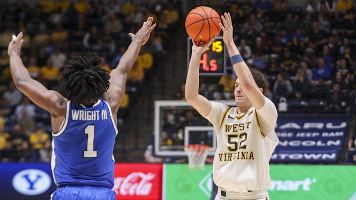 Feb 28, 2026; Morgantown, West Virginia, USA; West Virginia Mountaineers guard Treysen Eaglestaff (52) shoots a three pointer over BYU Cougars guard Robert Wright III (1) during the second half at Hope Coliseum. Mandatory Credit: Ben Queen-Imagn Images