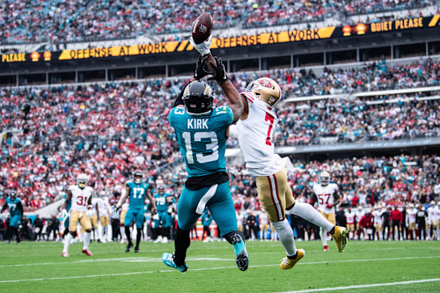 San Francisco 49ers cornerback Charvarius Ward (7) deflects the pass in a white jersey.