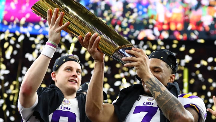 Jan 13, 2020; New Orleans, Louisiana, USA; LSU Tigers safety Grant Delpit (7) hoists the national championship trophy with quarterback Joe Burrow (9) after a victory against the Clemson Tigers in the College Football Playoff national championship game at Mercedes-Benz Superdome. 