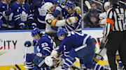 Nov 20, 2024; Toronto, Ontario, CAN; Toronto Maple Leafs defenseman Simon Benoit (2) fights with Vegas Golden Knights defenseman Zach Whitecloud (2) and forward Keegan Kolesar (55) fights with Toronto Maple Leafs defenseman Conor Timmins (25) after a hit on forward Matthew Knies (23) at Scotiabank Arena. Mandatory Credit: John E. Sokolowski-Imagn Images