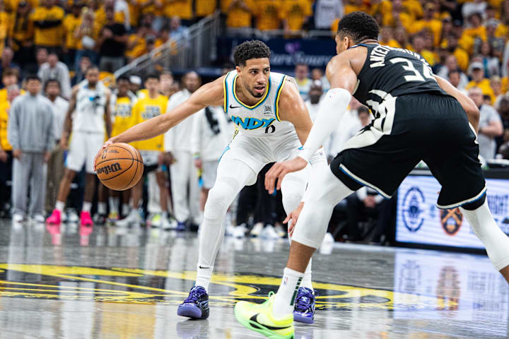 Indiana Pacers guard Tyrese Haliburton dribbles the ball while Milwaukee Bucks forward Giannis Antetokounmpo defends.