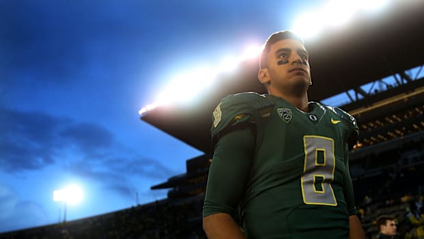 Marcus Mariota waits for a television interview after the Ducks' 44-10 win over the Buffaloes at Autzen Stadium in Eugene on 