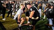 Nov 8, 2025; Nashville, Tennessee, USA;  Vanderbilt Commodores quarterback Diego Pavia (2) does the Heisman pose with a fan against the Auburn Tigers during the overtime period at FirstBank Stadium. Mandatory Credit: Steve Roberts-Imagn Images