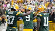 Oct 13, 2024; Green Bay, Wisconsin, USA;  Green Bay Packers wide receiver Romeo Doubs (87) celebrates with wide receivers Christian Watson (9) and Jayden Reed (11) after scoring a touchdown during the third quarter against the Arizona Cardinals at Lambeau Field. Mandatory Credit: Jeff Hanisch-Imagn Images