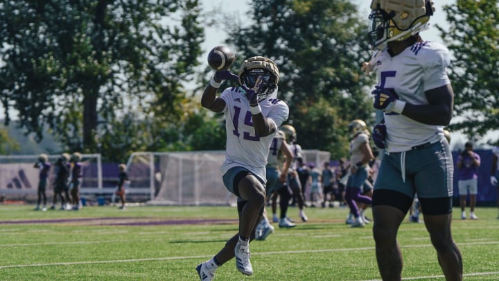 Keith Reynolds (15) makes a UW practice catch with Giles Jackson nearby.