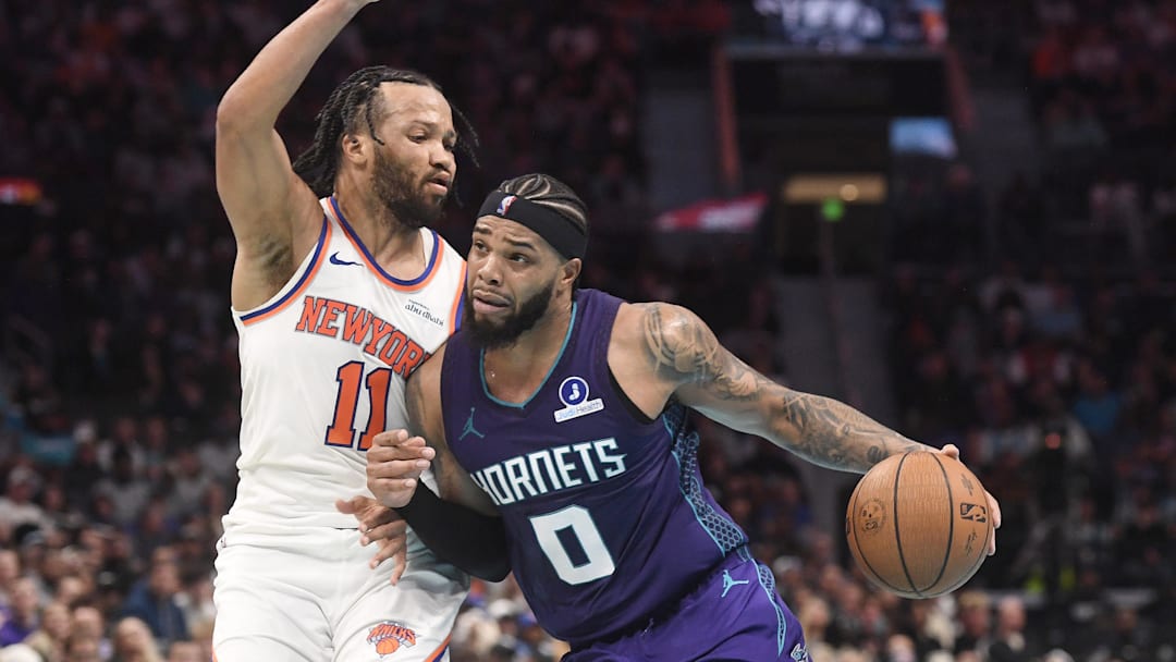 Nov 26, 2025; Charlotte, North Carolina, USA;  Charlotte Hornets forward Miles Bridges (0) drives past New York Knicks guard Jalen Brunson (11) during the second half at the Spectrum Center. Mandatory Credit: Sam Sharpe-Imagn Images