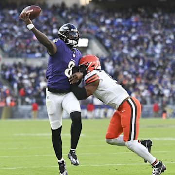 Nov 12, 2023; Baltimore, Maryland, USA;  Baltimore Ravens quarterback Lamar Jackson (8) throws on the run as Cleveland Browns defensive end Myles Garrett (95) hits at M&T Bank Stadium. Mandatory Credit: Tommy Gilligan-Imagn Images