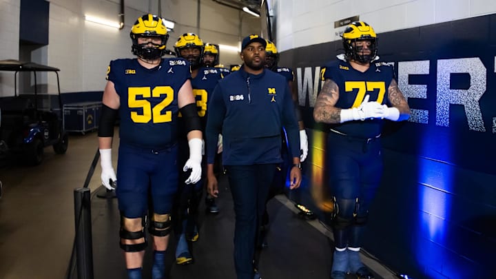 Jan 8, 2024; Houston, TX, USA; Michigan Wolverines offensive coordinator Sherrone Moore with offensive lineman Karsen Barnhart (52) and Trevor Keegan (77) against the Washington Huskies during the 2024 College Football Playoff national championship game at NRG Stadium. Mandatory Credit: Mark J. Rebilas-Imagn Images