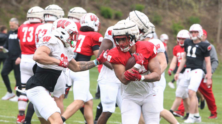 Wisconsin running back Jackson Acker braces for safety Braedyn Moore's tackle during the team's 10th spring practice, which was held on a practice field north of Camp Randall Stadium in Madison, Wisconsin on Saturday April 20, 2024.