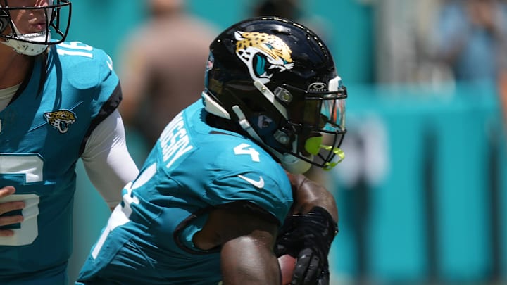 Sep 8, 2024; Miami Gardens, Florida, USA;  Jacksonville Jaguars quarterback Trevor Lawrence (16) hands off to running back Tank Bigsby (4) in the first quarter against the Miami Dolphins at Hard Rock Stadium. Mandatory Credit: Jim Rassol-Imagn Images