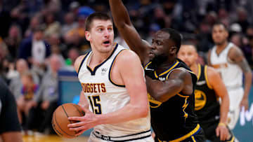 Apr 16, 2022; San Francisco, California, USA; Denver Nuggets center Nikola Jokic (15) controls the ball against Golden State Warriors forward Draymond Green (23) in the second quarter during game one of the first round for the 2022 NBA playoffs at the Chase Center. Mandatory Credit: Cary Edmondson-Imagn Images