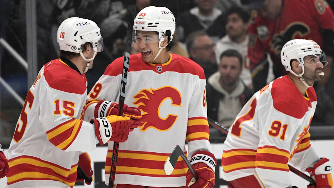 Apr 17, 2025; Los Angeles, California, USA;   Calgary Flames left wing Dryden Hunt (15), defenseman Zayne Parekh (89) and center Nazem Kadri (91) celebrate after a goal in the third period against the Los Angeles Kings at Crypto.com Arena. Mandatory Credit: Jayne Kamin-Oncea-Imagn Images