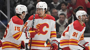 Apr 17, 2025; Los Angeles, California, USA;   Calgary Flames left wing Dryden Hunt (15), defenseman Zayne Parekh (89) and center Nazem Kadri (91) celebrate after a goal in the third period against the Los Angeles Kings at Crypto.com Arena. Mandatory Credit: Jayne Kamin-Oncea-Imagn Images