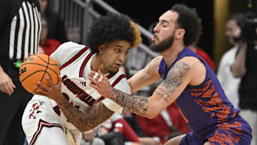 Jan 7, 2025; Louisville, Kentucky, USA;  Louisville Cardinals guard Chucky Hepburn (24) looks to pass under the pressure of Clemson Tigers guard Jaeden Zackery (11) during the first half at KFC Yum! Center. Mandatory Credit: Jamie Rhodes-Imagn Images