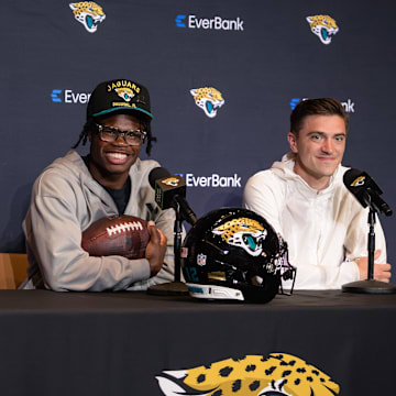 Apr 25, 2025; Jacksonville, FL, USA; Jacksonville Jaguars head coach Liam Coen  and first round draft pick Travis Hunter talk to the media during a press conference at Miller Electric Center. Mandatory Credit: Travis Register-Imagn Images