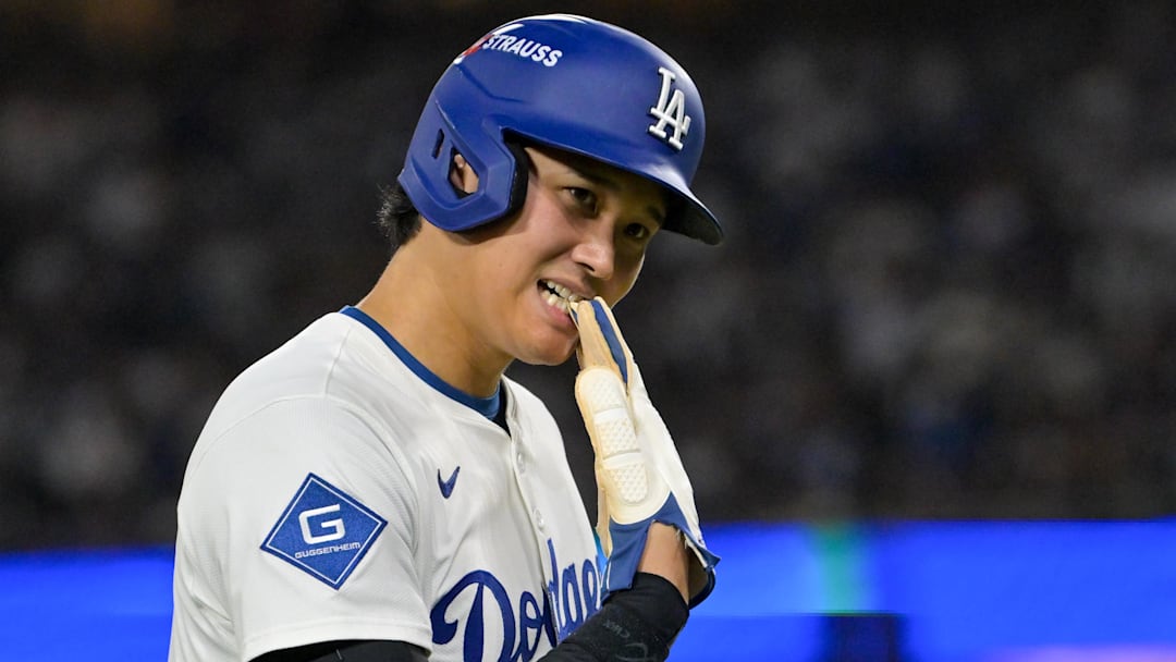 Los Angeles Dodgers designated hitter Shohei Ohtani (17) removes his glove during a pitching change for the Cincinnati Reds in the seventh inning during game two of the Wildcard round for the 2025 MLB playoffs at Dodger Stadium.