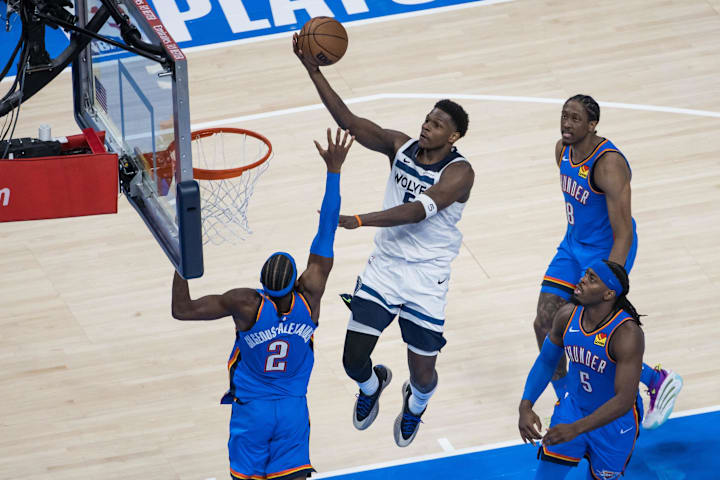 Minnesota Timberwolves guard Anthony Edwards drives against Oklahoma City Thunder guard Shai Gilgeous-Alexander.