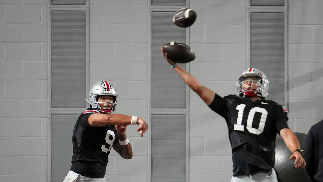 Ohio State Buckeyes quarterback Tavien St. Clair (9) passes behind quarterback Julian Sayin (10) during football training camp inside the Woody Hayes Athletic Center in Columbus on Aug. 7, 2026.