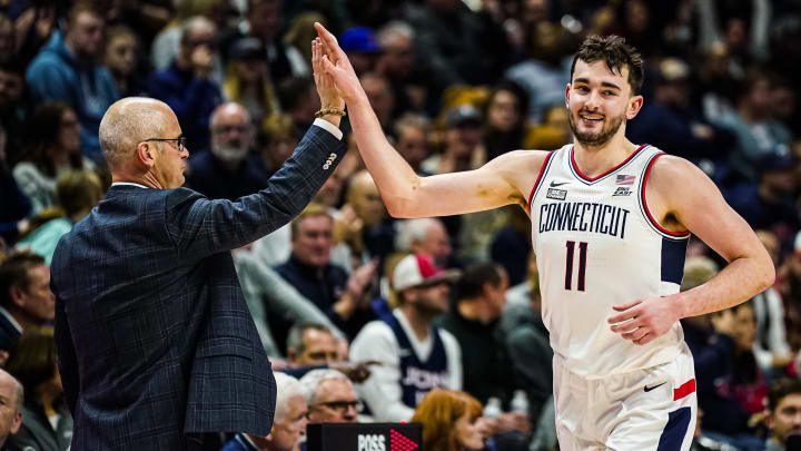 Connecticut Huskies head coach Dan Hurley congratulates forward Alex Karaban (11) coming off the court. 