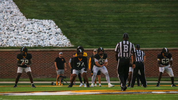 The starting offensive line for the Missouri Tigers drop into stance at the team's annual fan night practice at Faurot Field.