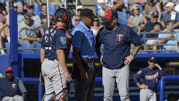 A group of men wearing blue uniforms and baseball equipment standing in front of a blue background