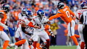 Oct 19, 2025; Denver, Colorado, USA; New York Giants quarterback Jaxson Dart (6) is sacked by Denver Broncos defensive end Zach Allen (99) and linebacker Jonathon Cooper (0) as guard Jon Runyan Jr. (76) defends in the fourth quarter at Empower Field at Mile High.  
