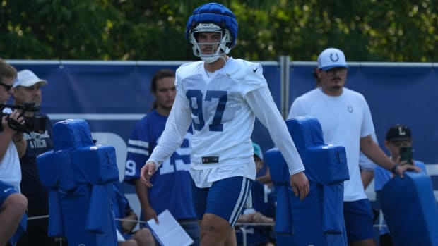 Colts rookie defensive end Laiatu Latu (white jersey with blue numbers) walks on the sideline during training camp. 