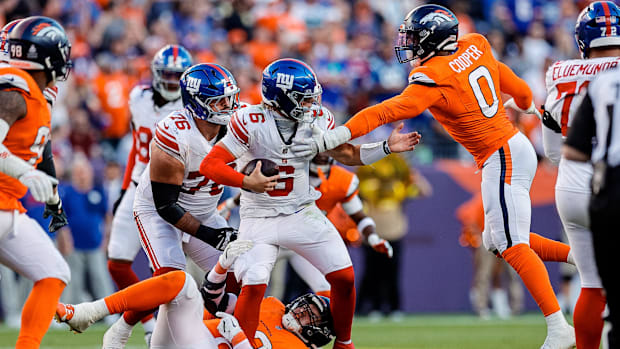 Denver Broncos outside linebacker Jonathon Cooper (0) gets a hand on New York Giants quarterback Jaxson Dart (6). 