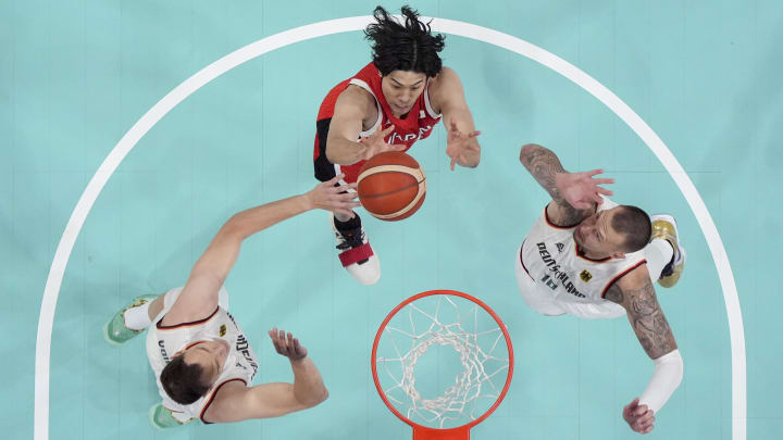 Jul 27, 2024; Villeneuve-d'Ascq, France; Germany centre Johannes Voigtmann (7), Japan small forward Hirotaka Yoshii (91) and Germany power forward Daniel Theis (10) go up at the net during the Paris 2024 Olympic Summer Games at Stade Pierre-Mauroy.