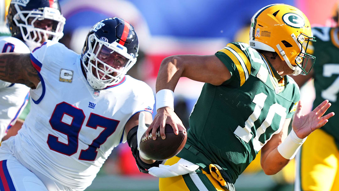 Nov 16, 2025; East Rutherford, New Jersey, USA; Green Bay Packers quarterback Jordan Love (10) scrambles away from New York Giants defensive tackle Dexter Lawrence II (97) during the first quarter at MetLife Stadium. Mandatory Credit: Robert Deutsch-Imagn Images