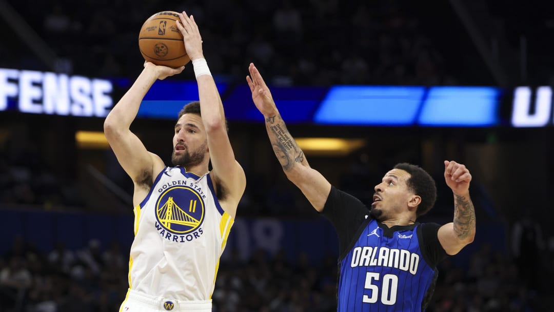 Mar 27, 2024; Orlando, Florida, USA;  Golden State Warriors guard Klay Thompson (11) shoots the ball past Orlando Magic guard Cole Anthony (50) in the fourth quarter at the Kia Center. Mandatory Credit: Nathan Ray Seebeck-USA TODAY Sports