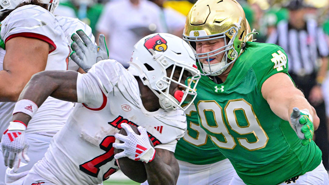 Sep 28, 2024; South Bend, Indiana, USA; Louisville Cardinals running back Isaac Brown (25) runs the ball against Notre Dame Fighting Irish defensive lineman Rylie Mills (99) in the third quarter at Notre Dame Stadium. Mandatory Credit: Matt Cashore-Imagn Images