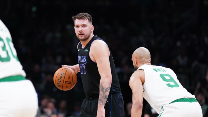 Jun 6, 2024; Boston, Massachusetts, USA; Dallas Mavericks guard Luka Doncic (77) controls the ball against Boston Celtics guard Derrick White (9) in the first quarter during game one of the 2024 NBA Finals at TD Garden.