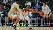Dec 21, 2024; Coral Gables, Florida, USA; Miami Hurricanes guard A.J. Staton-McCray (11) protects the basketball from Mount St. Mary's Mountaineers guard Xavier Lipscomb (45) during the first half at Watsco Center. Mandatory Credit: Sam Navarro-Imagn Images