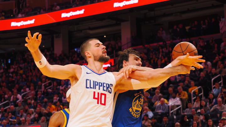 Nov 30, 2023; San Francisco, California, USA; Los Angeles Clippers center Ivica Zubac (40) and Golden State Warriors forward Dario Šarić (20) extend for a rebound during the second quarter at Chase Center.