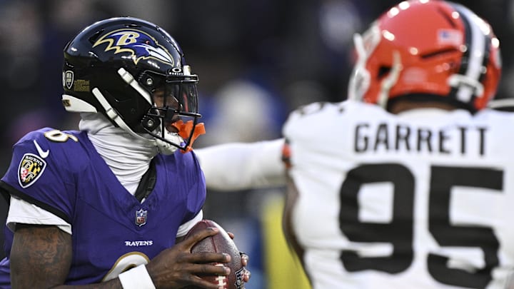 Jan 4, 2025; Baltimore, Maryland, USA;  Baltimore Ravens quarterback Lamar Jackson (8) looks to pass as Cleveland Browns defensive end Myles Garrett (95) applies pressure during the first half at M&T Bank Stadium. Mandatory Credit: Tommy Gilligan-Imagn Images